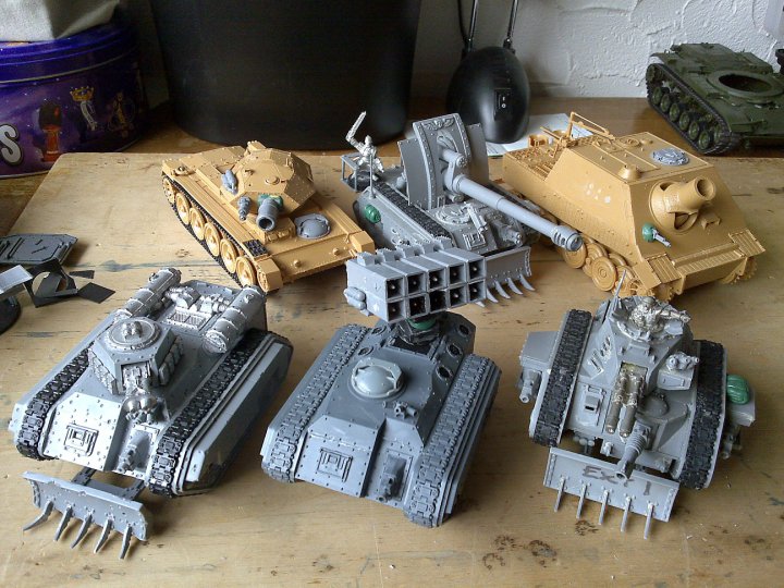From Top, Going Right: Desert Tank (Based on Crusader), Command Basilisk SPG, Heavy Mortar (Based on SturmTiger), Classic Hellhound, The MLRS Chimera, Classic Leman Russ Exterminator.<br /><br />The Green Tank Chassis at the rear on the right is a base for a new Super Heavy Tank I'm working on, based on an M60 1/35th kit