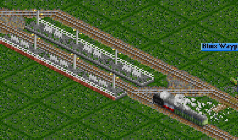Train entering the station with mail van (white-red) in the head, with the locomotive boiler-forward...